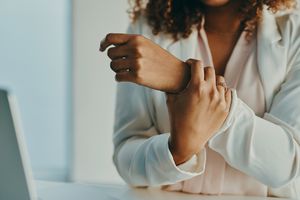 woman holding her hand in pain 