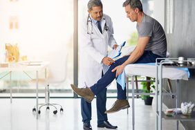 doctor giving man a physical exam for psoriatic arthritis