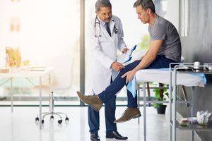 doctor giving man a physical exam for psoriatic arthritis
