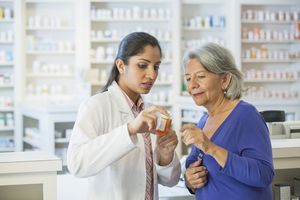 Pharmacist explaining medication to older woman
