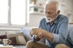 older man holding wrist in pain