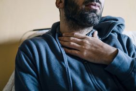 Young adult man suffering from sore throat