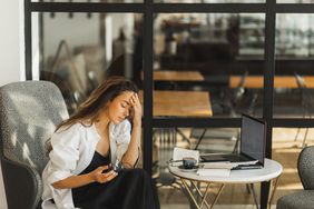 A woman feeling burnout in front of her laptop computer