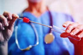 Close up of nurses hands holding buccal cotton swab and test tube ready to collect DNA from the cells. coronavirus-antigen-test , covid-19 , coronavirus-test , coronvirus, antigen-test