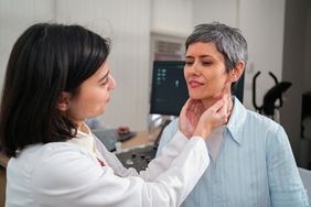 woman getting her thyroid checked out by a doctor 