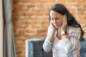 person experiencing tinnitus symptoms in ears