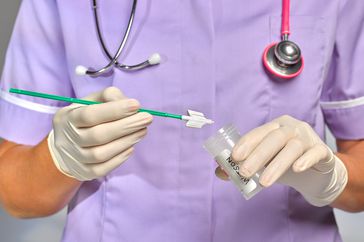 A doctor doing a smear STI test