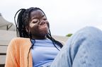 woman with vitiligo wearing layers and sitting in the sun