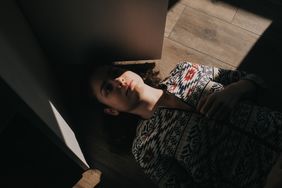 Woman on floor half in shadow depressed