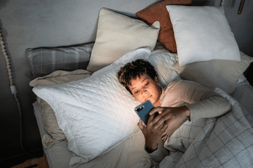 woman using smart phone in bed