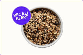 bowl of uncooked rice on white background with recall sticker